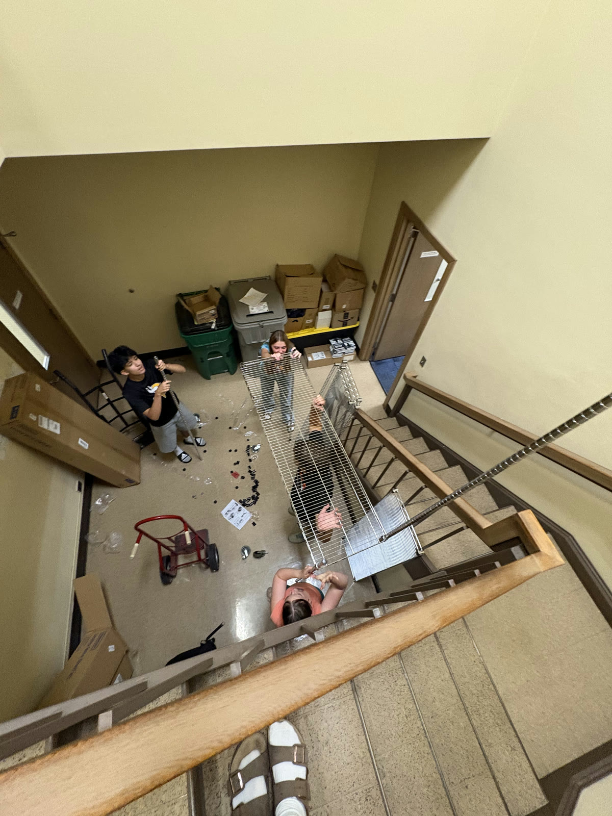 Students assembling metal shelving in the new snack storage room